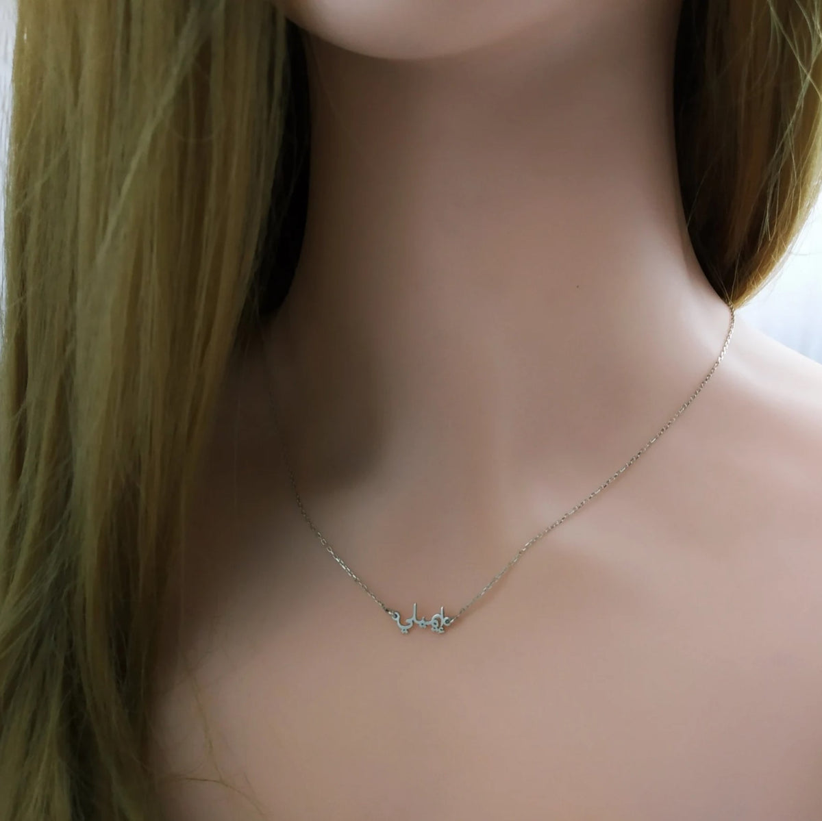 Tiny Arabic name necklace from MUHVA STORE featuring a delicate gold chain and personalized Arabic script pendant.