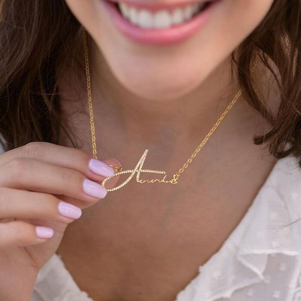 Gold signature diamond name necklace from MUHVA STORE featuring a personalized name pendant with sparkling diamonds.