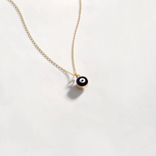 Silver evil eye pendant necklace with blue and white eye design, hanging from a delicate chain, by MUHVA STORE.
