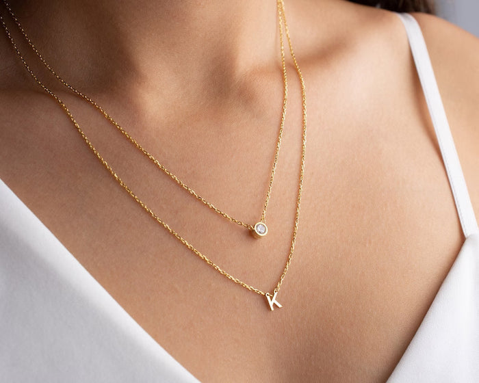 Gold diamond initial layer necklace with a delicate pendant, showcasing a personalized initial design from MUHVA STORE.