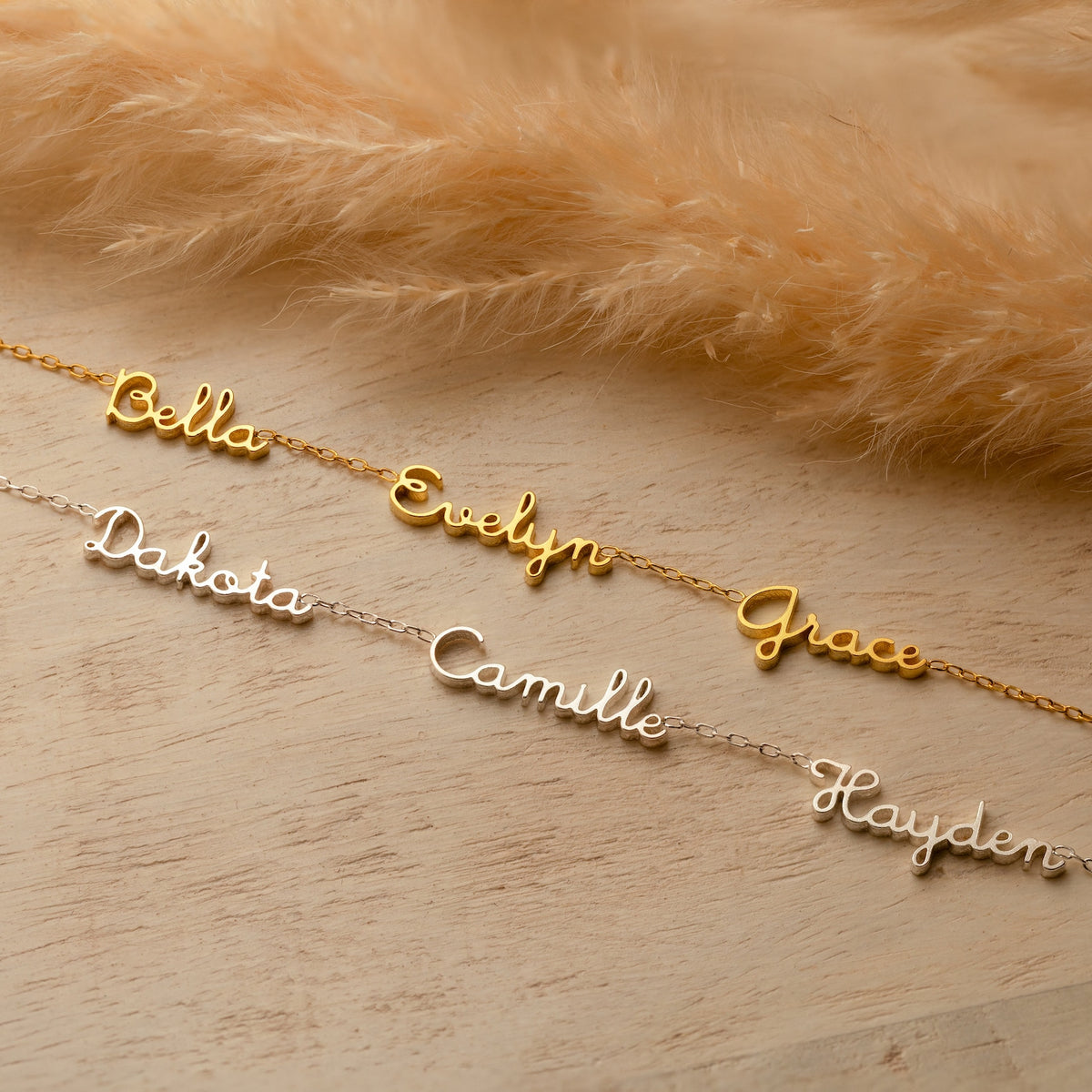 Tiny multiple name necklace by MUHVA STORE, featuring delicate chain with personalized name pendants on a white background.