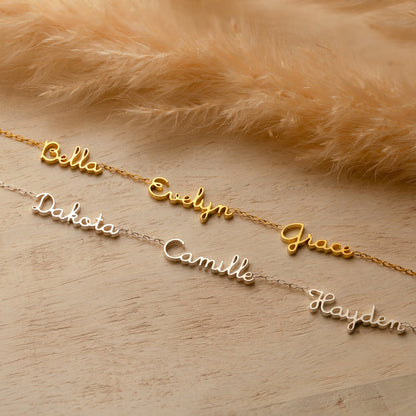 Tiny multiple name necklace by MUHVA STORE, featuring delicate chain with personalized name pendants on a white background.