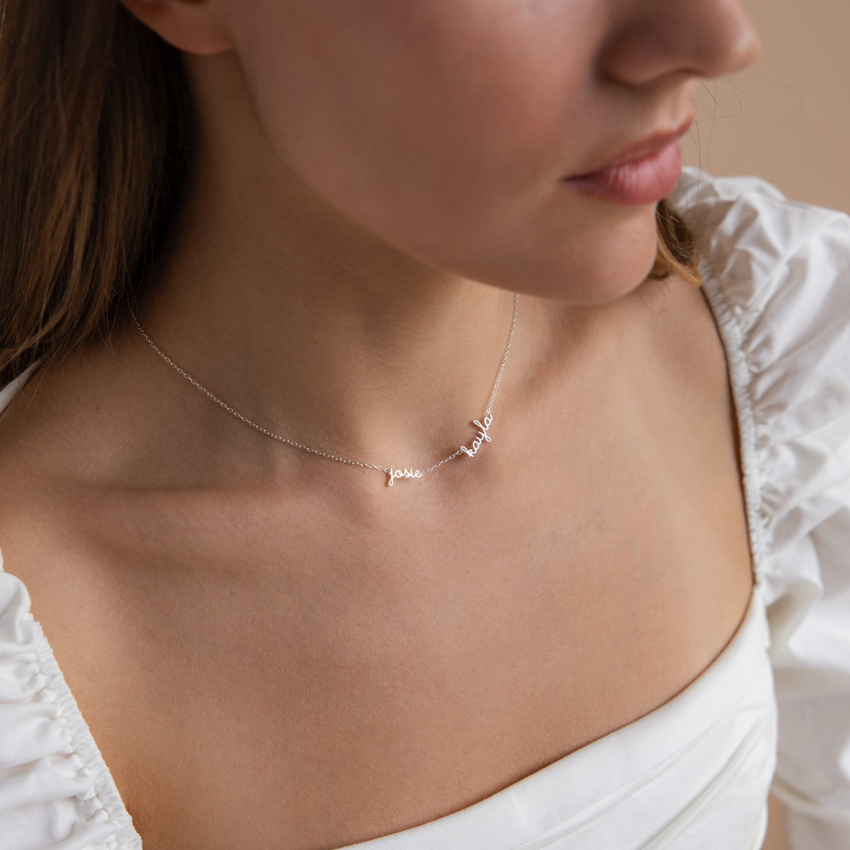 Tiny multiple name necklace by MUHVA STORE featuring delicate gold chain and personalized name pendants on a white background.