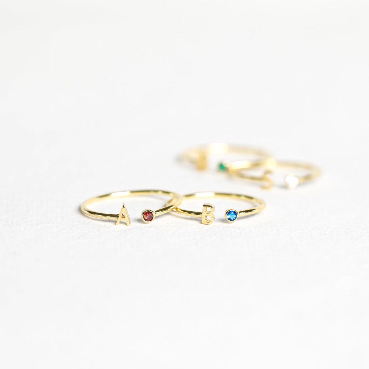 Gold custom initial birthstone ring with engraved initial and sparkling birthstone, designed by MUHVA STORE.