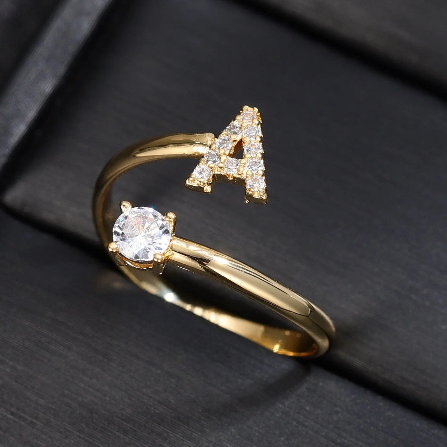Diamond letter ring from MUHVA STORE featuring a sleek band with a sparkling diamond-encrusted letter design.