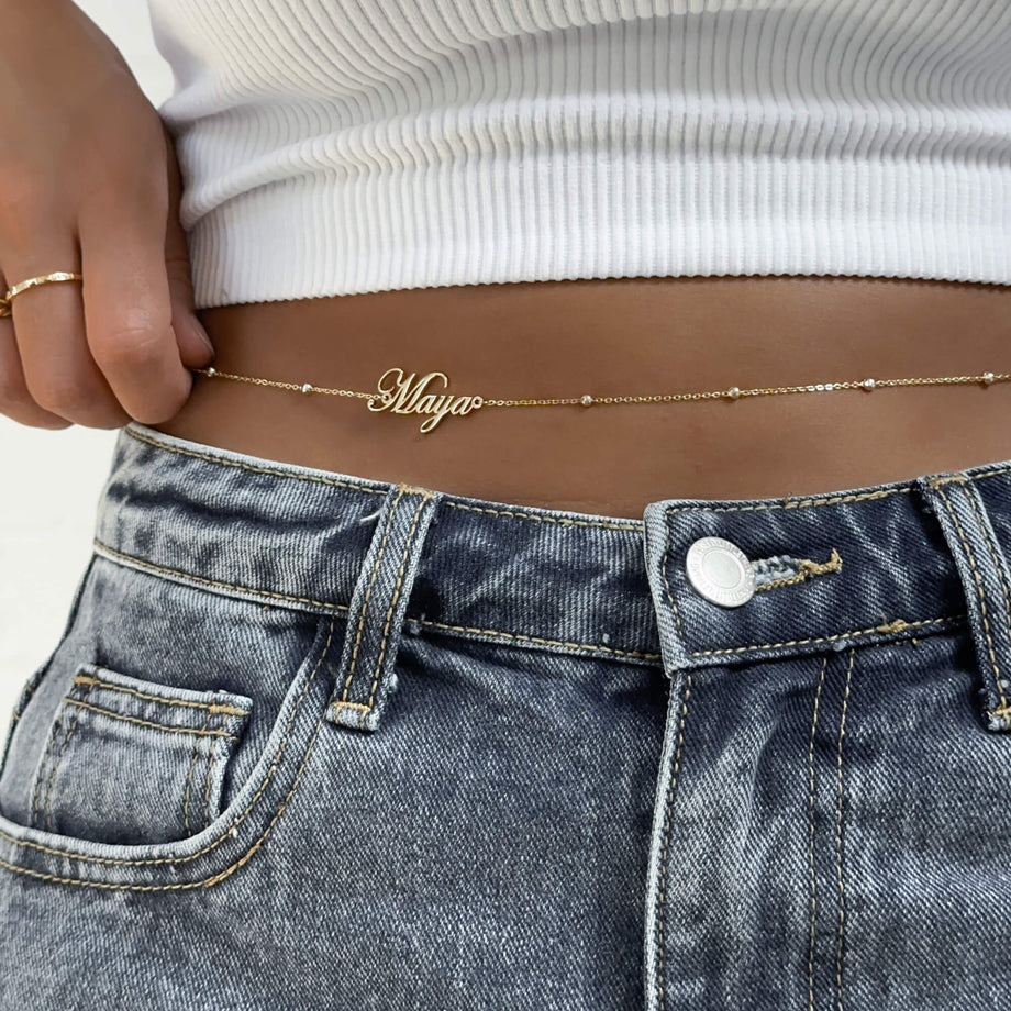 Gold custom name belly chain from MUHVA STORE featuring delicate chain and personalized name pendant on the waist.
