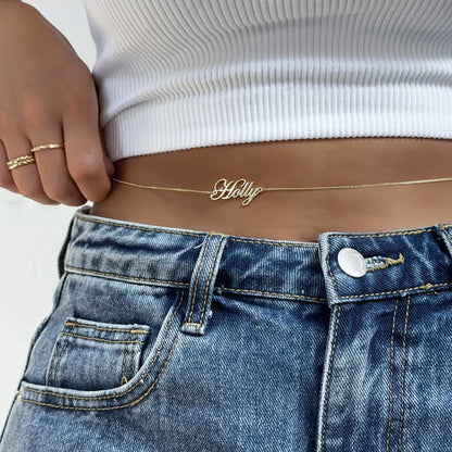 Personalized name belly chain from MUHVA STORE featuring a delicate gold chain with custom name pendant on a model.