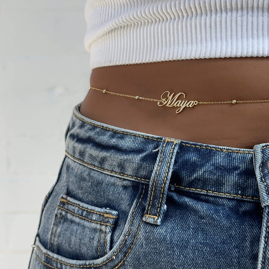 Personalized name belly chain from MUHVA STORE with delicate chain and custom engraved name for stylish beach or festival wear.