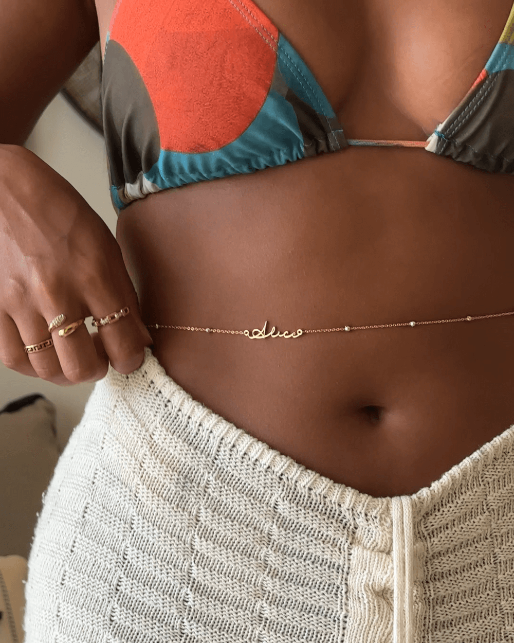 Custom name belly chain from MUHVA STORE featuring a delicate gold chain with personalized name pendant, perfect for summer wear.