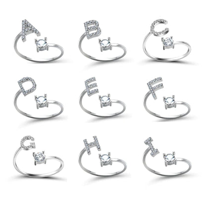Pair of initial letter rings from MUHVA STORE featuring engraved letter "R" designs in silver-tone metal.