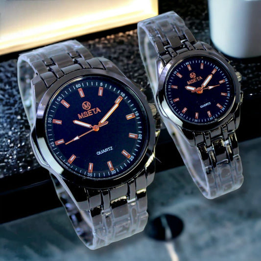 Pair of Muhva Store MSETA Couple Watch M-002 with matching black and white watch faces on a wooden surface.