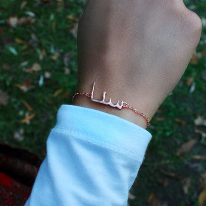 Personalized Arabic name bracelet from Muhva Store featuring custom engraved name on sleek metal band.