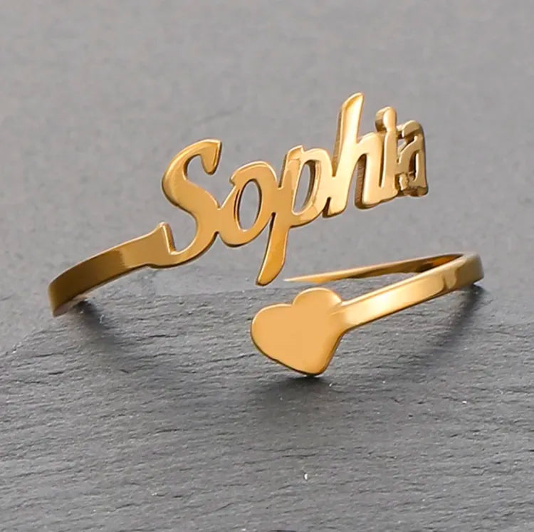Pair of adjustable custom name rings by Muhva Store featuring personalized engraved names on sleek metal bands.