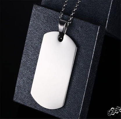 Two silver customized pendants with intricate designs, featuring personalized engravings, on a plain background.