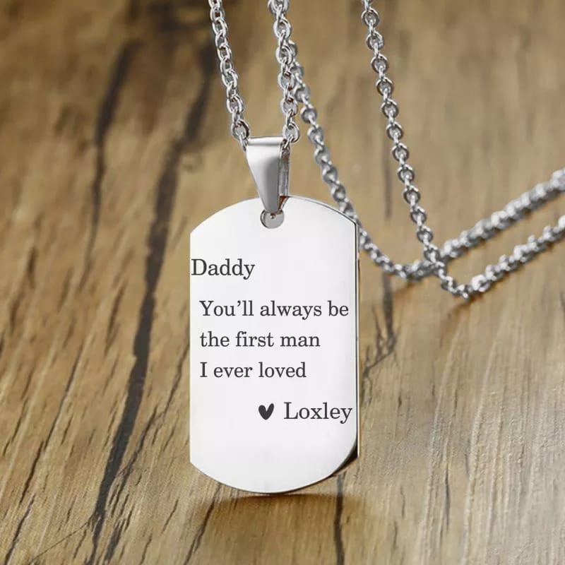 Two silver customized pendants with engraved designs, hanging from delicate chains, showcasing personalized jewelry.