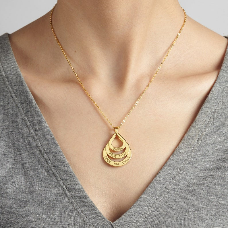 Personalized gold drop necklace with three name pendants from MUHVA STORE, featuring elegant chain and custom engraving.