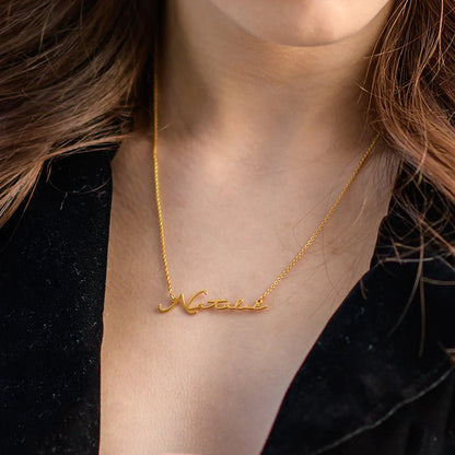 Gold plated signature name necklace from MUHVA STORE, featuring a personalized name pendant on a delicate chain.