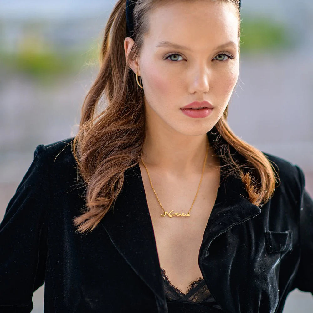 Gold plated signature name necklace from MUHVA STORE, featuring a personalized engraved pendant on a delicate chain.