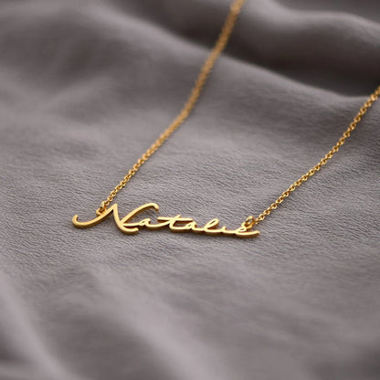 Gold plated signature name necklace from MUHVA STORE, featuring a personalized engraved pendant on a delicate chain.