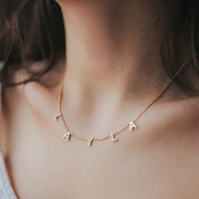 Gold space letter name necklace by MUHVA STORE featuring a personalized celestial-themed pendant on a delicate chain.
