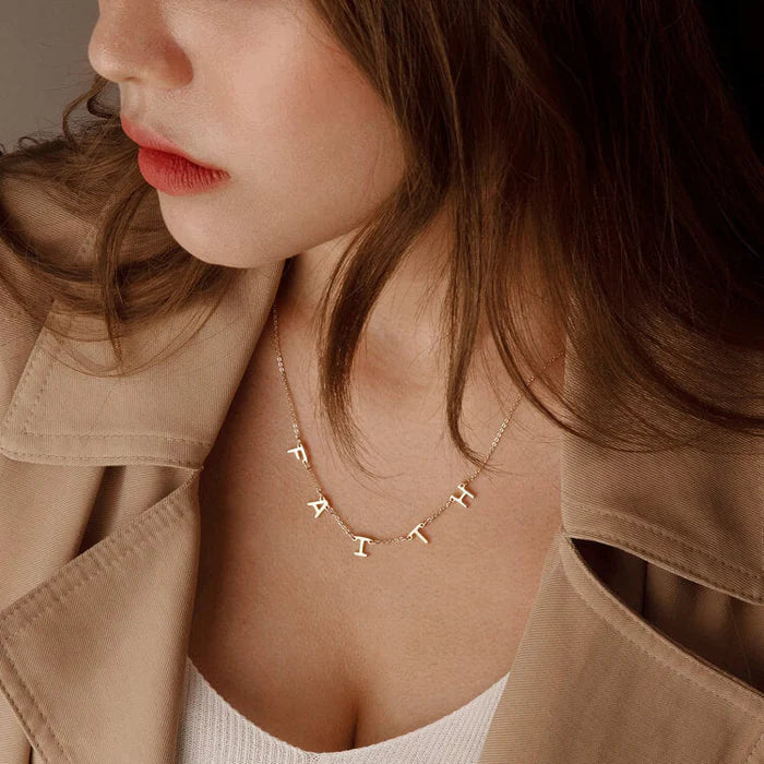 Silver space letter name necklace by MUHVA STORE featuring individual letter charms on a delicate chain.